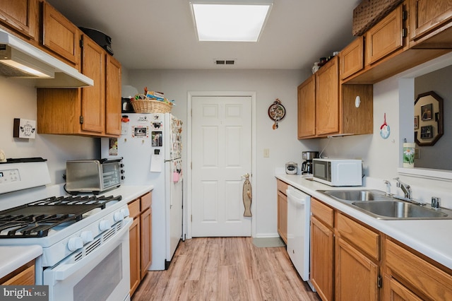 kitchen with sink, white appliances, and light hardwood / wood-style floors