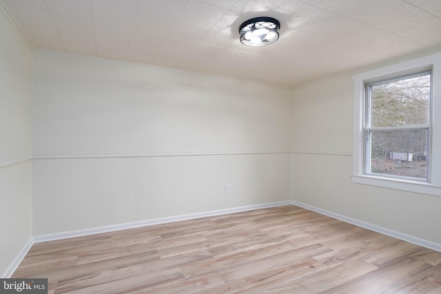 unfurnished room featuring ornamental molding and light wood-type flooring