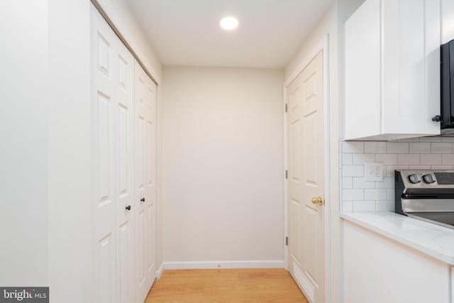 corridor with light hardwood / wood-style floors