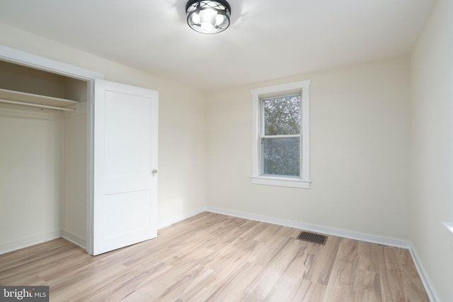 unfurnished bedroom with light hardwood / wood-style flooring and a closet