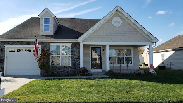 view of front of property with a garage, cooling unit, covered porch, and a front lawn