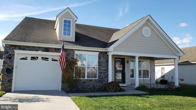 view of front of property with a garage, covered porch, and a front lawn