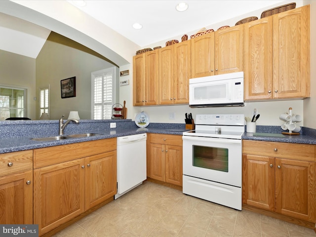 kitchen featuring white appliances, lofted ceiling, and sink