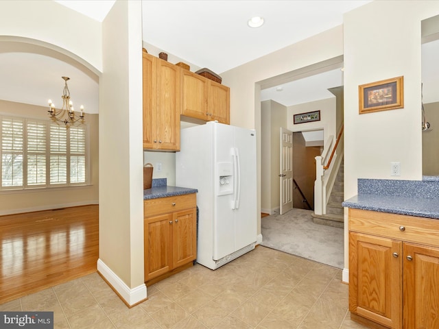 kitchen with decorative light fixtures, an inviting chandelier, and white fridge with ice dispenser