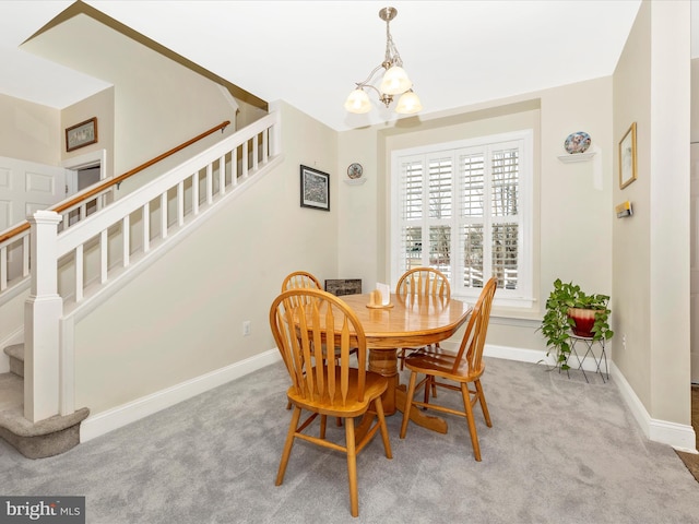 carpeted dining space featuring a chandelier