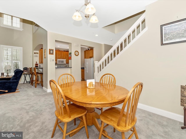 dining room featuring light carpet and a notable chandelier