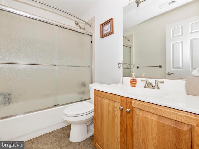 full bathroom with combined bath / shower with glass door, vanity, tile patterned flooring, and toilet