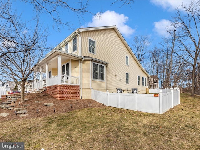 view of side of property with a yard, a porch, and central AC