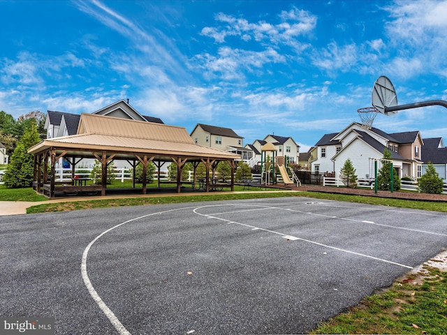 view of sport court featuring a playground, a lawn, and a gazebo