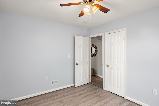 unfurnished bedroom featuring light wood-style flooring, baseboards, and ceiling fan