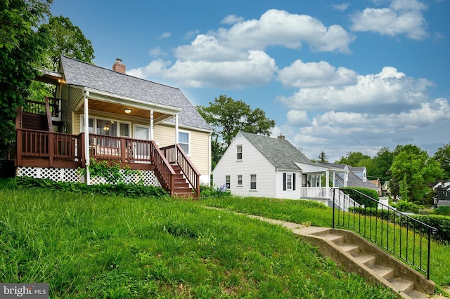 back of property featuring stairway, a chimney, and covered porch
