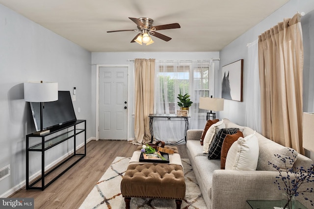 living area with ceiling fan, wood finished floors, and baseboards