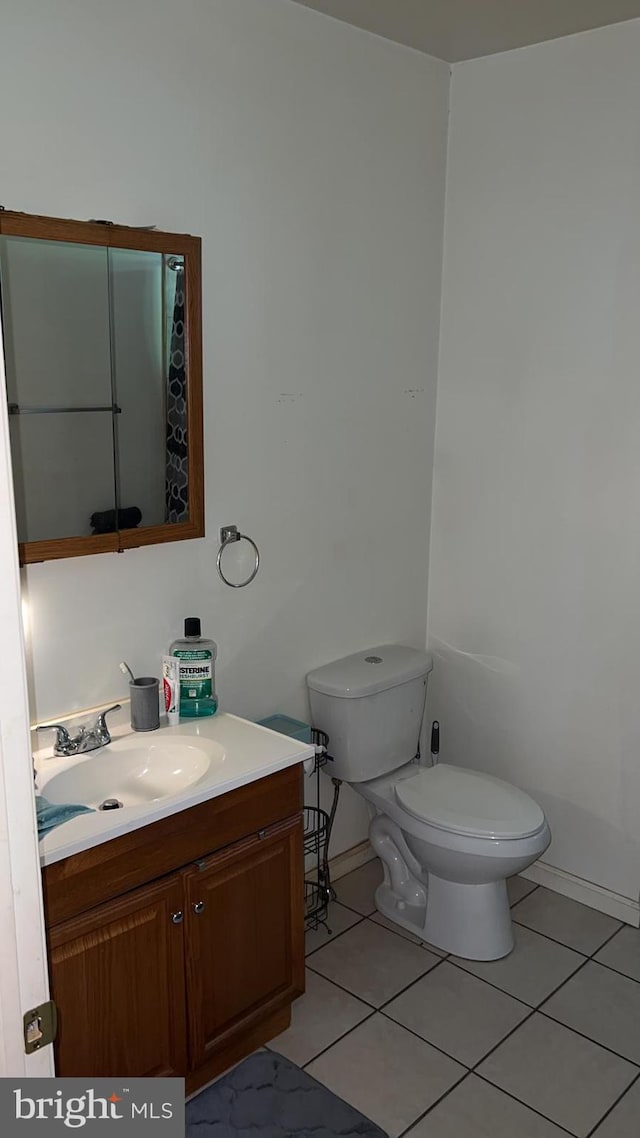 bathroom with vanity, tile patterned flooring, and toilet