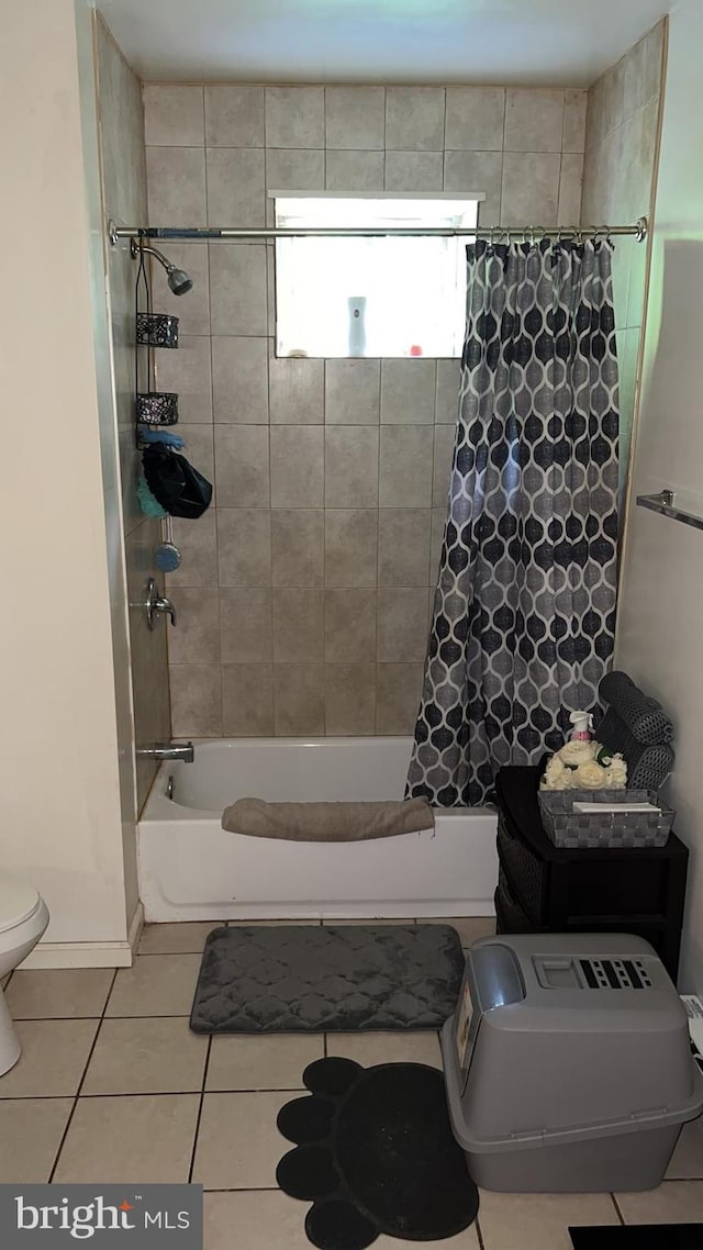 bathroom with shower / tub combo, tile patterned floors, and toilet