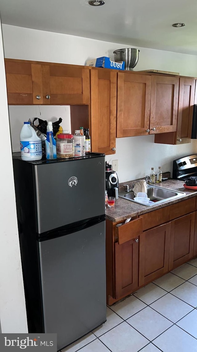 kitchen with sink, stainless steel appliances, and light tile patterned flooring