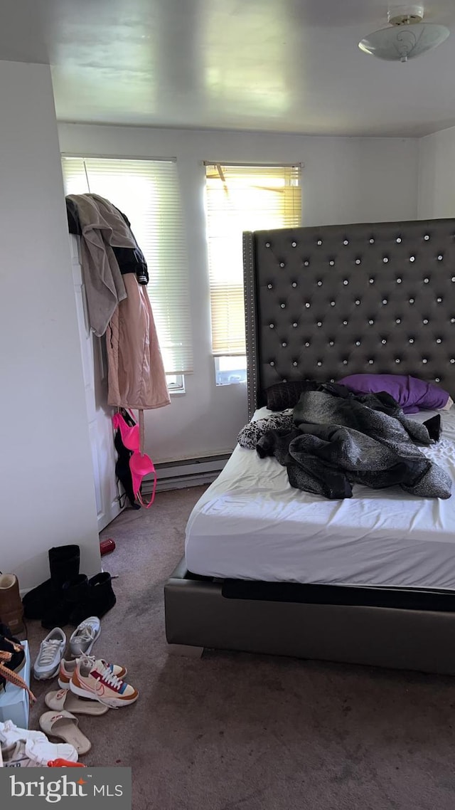 bedroom featuring a baseboard heating unit and carpet flooring