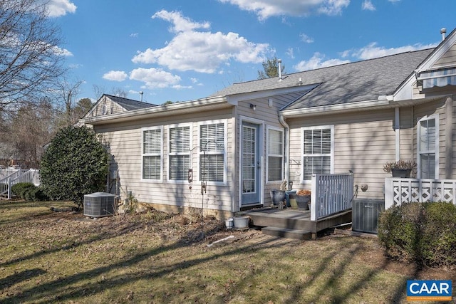 back of house with central AC and a lawn