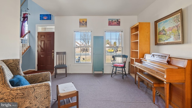 living area featuring dark carpet and baseboards