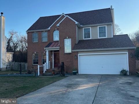 view of front facade featuring driveway, brick siding, and an attached garage