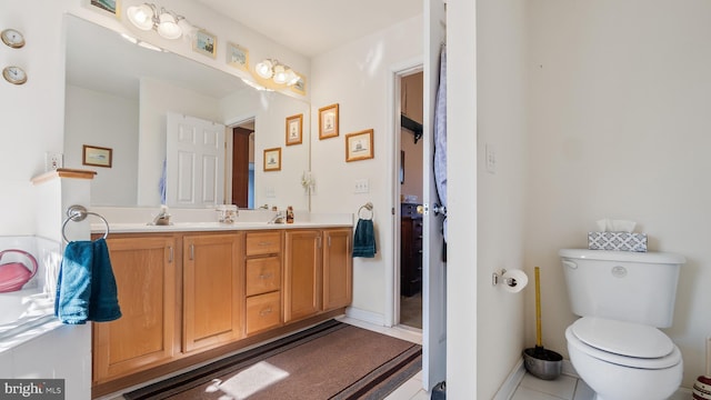 bathroom with tile patterned floors, a sink, toilet, and double vanity