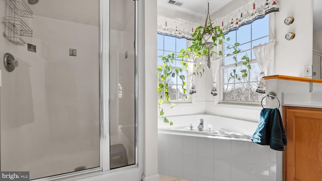 full bathroom with visible vents, a stall shower, a garden tub, and vanity