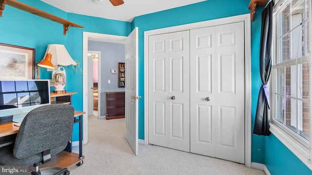 office area with baseboards, a ceiling fan, and light colored carpet