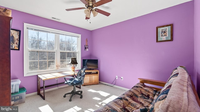 home office with visible vents, ceiling fan, light carpet, and baseboards