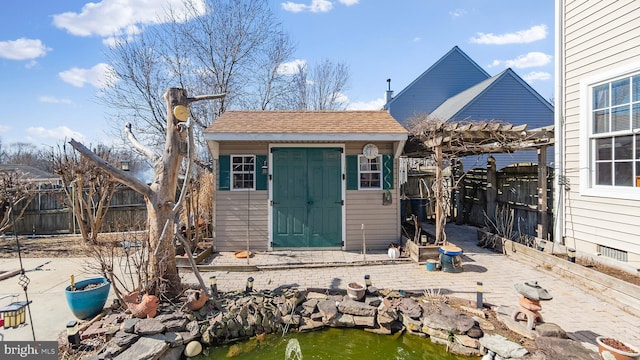 view of shed featuring fence and a pergola