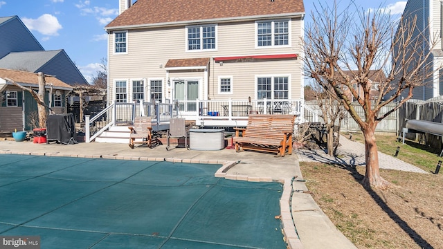 back of property with a fenced in pool, a patio, a chimney, fence, and a deck