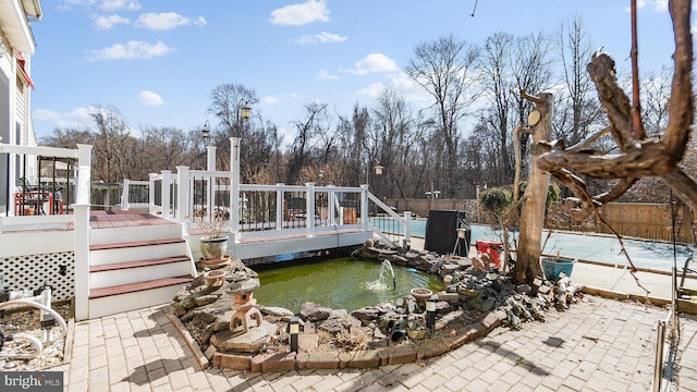 exterior space featuring a deck, fence, and a fenced in pool