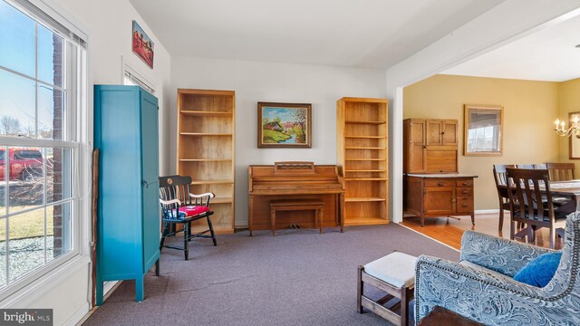 sitting room featuring carpet floors, baseboards, and a chandelier