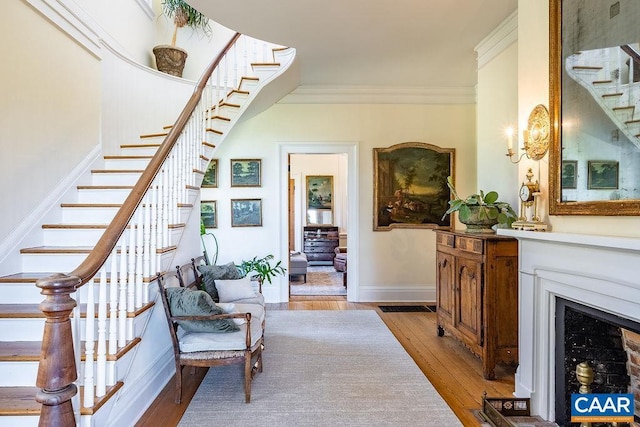 stairway with crown molding and hardwood / wood-style flooring