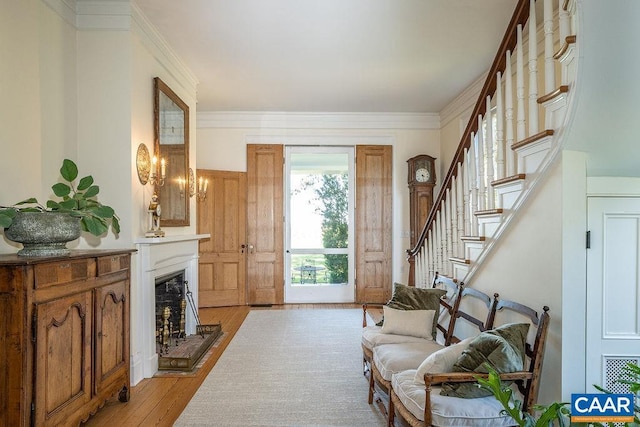 sitting room with ornamental molding and light hardwood / wood-style floors