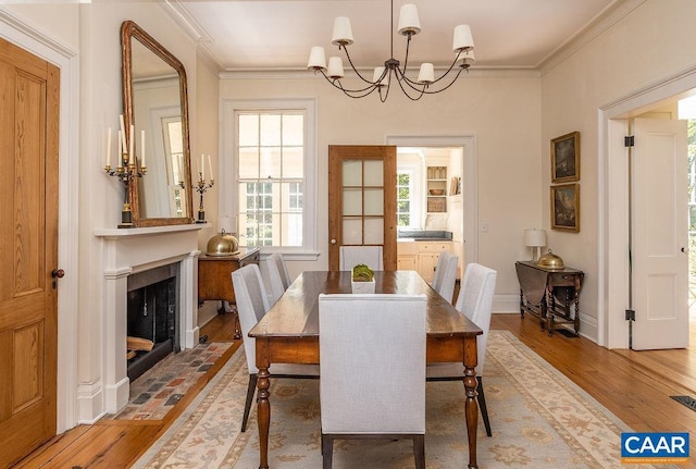 dining room with crown molding, a chandelier, and hardwood / wood-style flooring