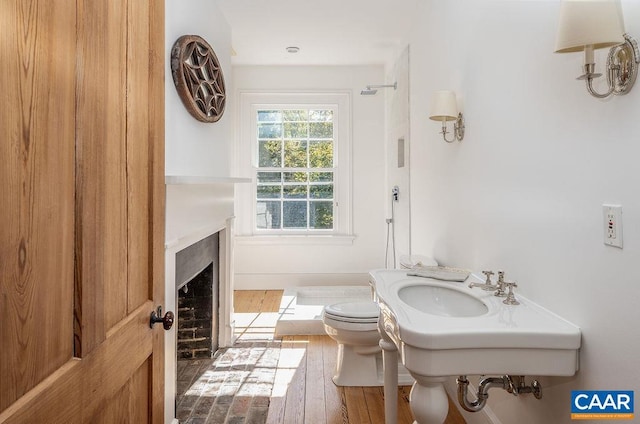 bathroom with hardwood / wood-style floors and toilet