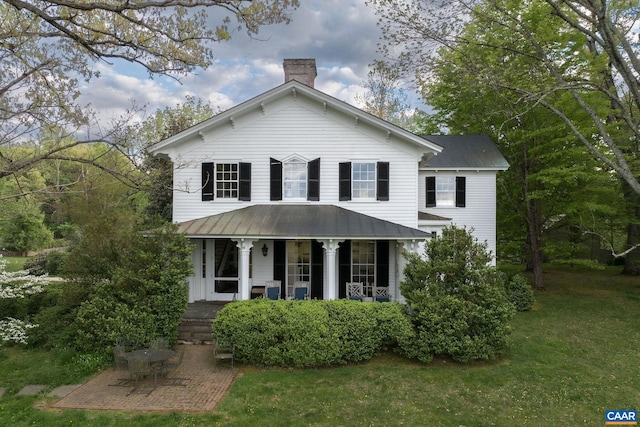 view of front of property featuring covered porch and a front lawn