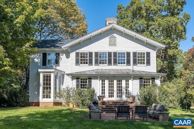 back of house with french doors, a patio, and a lawn