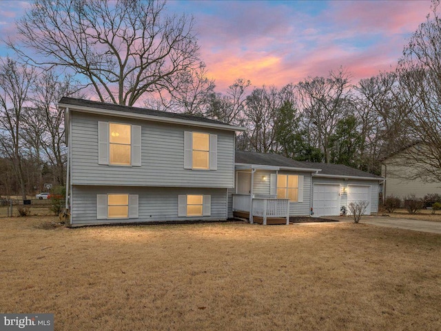 split level home featuring a garage and a lawn