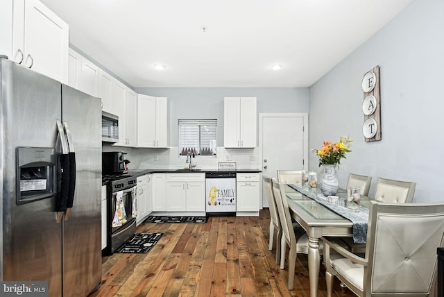 kitchen featuring tasteful backsplash, sink, white cabinets, and appliances with stainless steel finishes