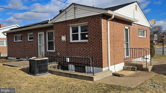 rear view of house with a yard and central AC unit