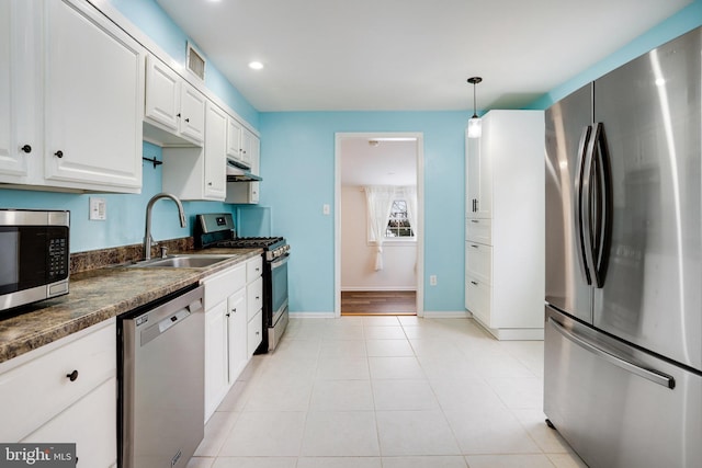 kitchen with sink, light tile patterned floors, appliances with stainless steel finishes, white cabinetry, and hanging light fixtures