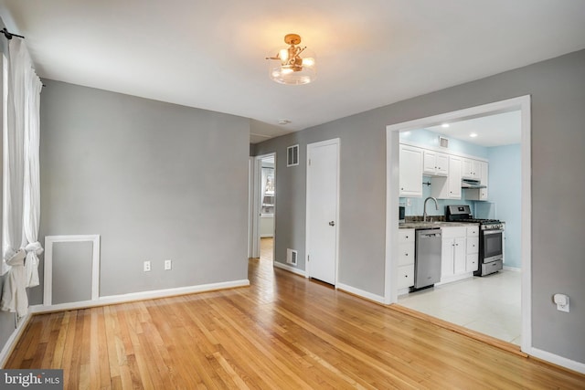 interior space with sink, an inviting chandelier, and light hardwood / wood-style floors