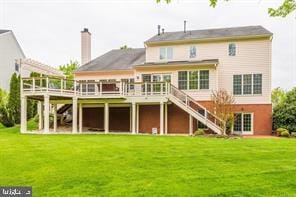 back of house with a wooden deck, a lawn, a chimney, and stairs