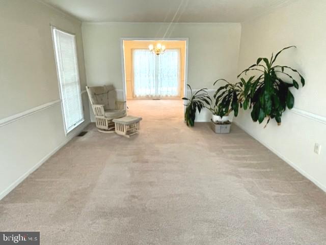 sitting room with carpet and a notable chandelier