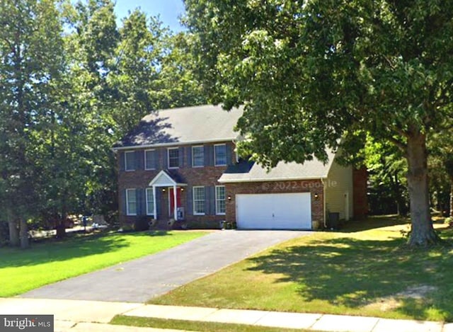 view of front of house featuring driveway, a front lawn, and brick siding