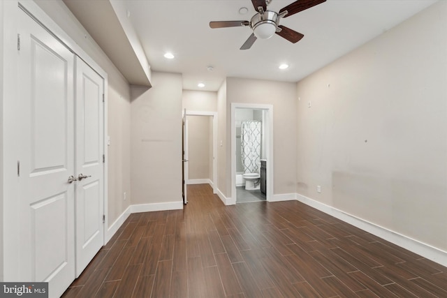 unfurnished bedroom with ensuite bathroom and dark hardwood / wood-style floors