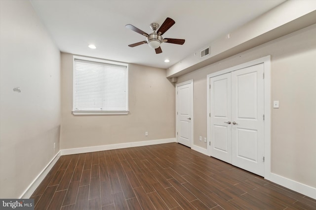 unfurnished bedroom featuring dark wood-type flooring, ceiling fan, and a closet