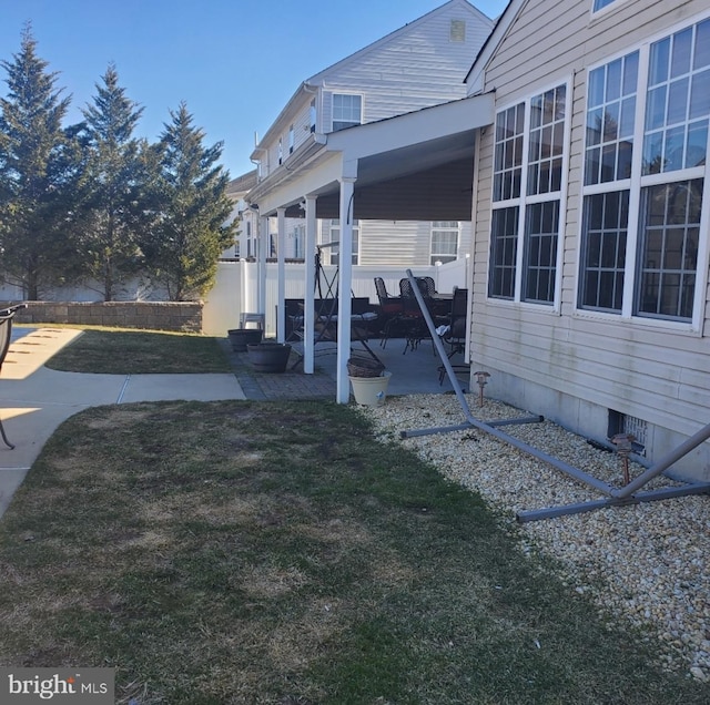 view of home's exterior with a patio, crawl space, and a lawn