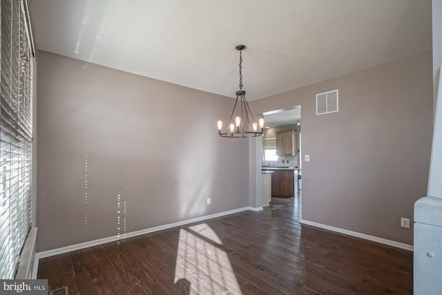 unfurnished room featuring dark wood-type flooring, visible vents, and baseboards