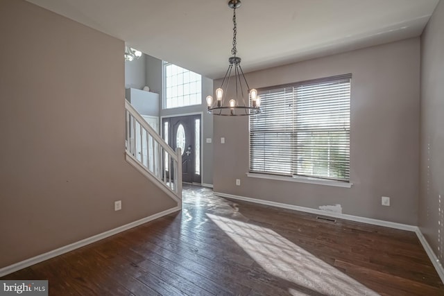 foyer entrance featuring a wealth of natural light, baseboards, and dark wood-style flooring